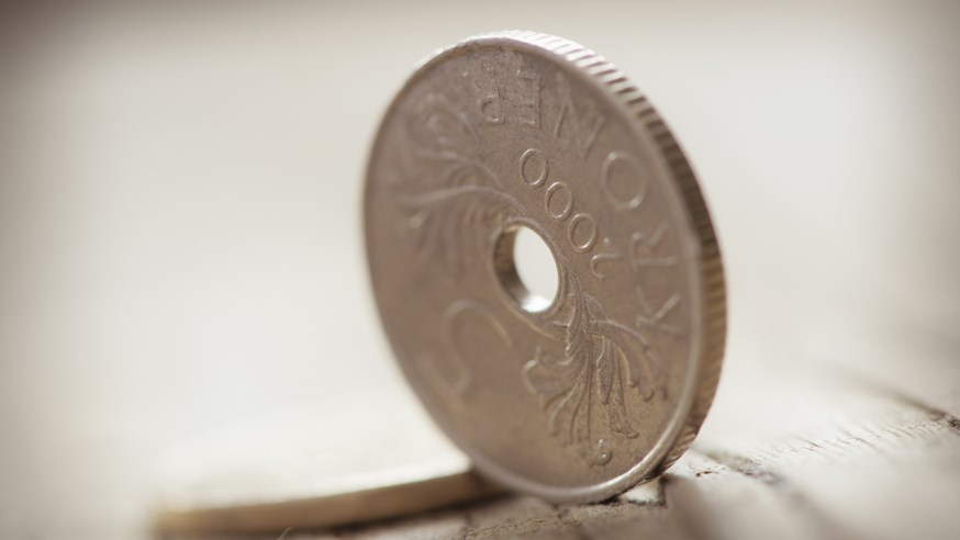Stående fem krone mynt  og en liggende mynt. foto